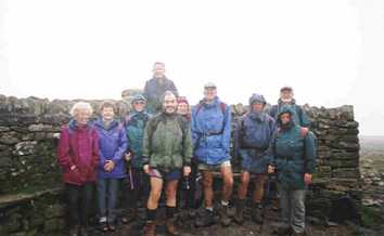 In the mist on top of Ingleborough, we huddle together to keep warm